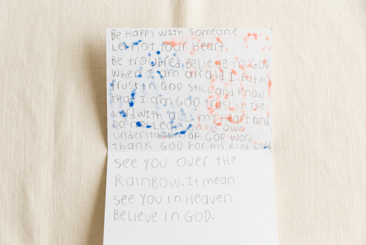Inside spread of a handmade card by Andrew with a hand-lettered scripture message and blue and coral paint splatter.